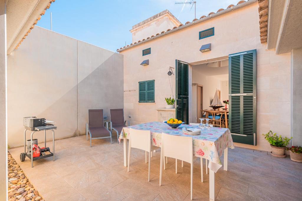 a patio with a table and chairs and a grill at Es Pop Nou in Sa Ràpita
