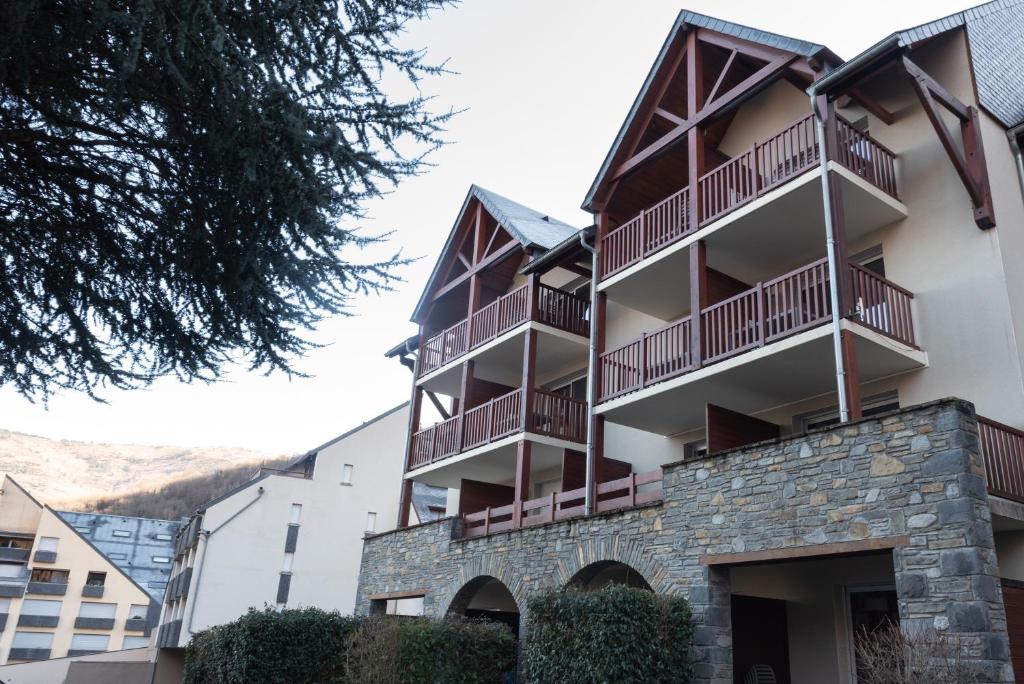 a building with balconies on the side of it at T2 avec piscine couverte et parking in Saint-Lary-Soulan