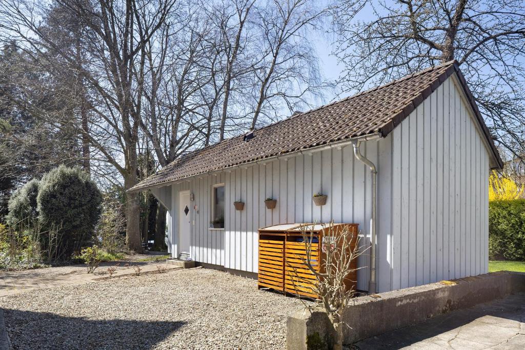 a white building with a trash can in front of it at Ferienhaus Gerster in Mitten