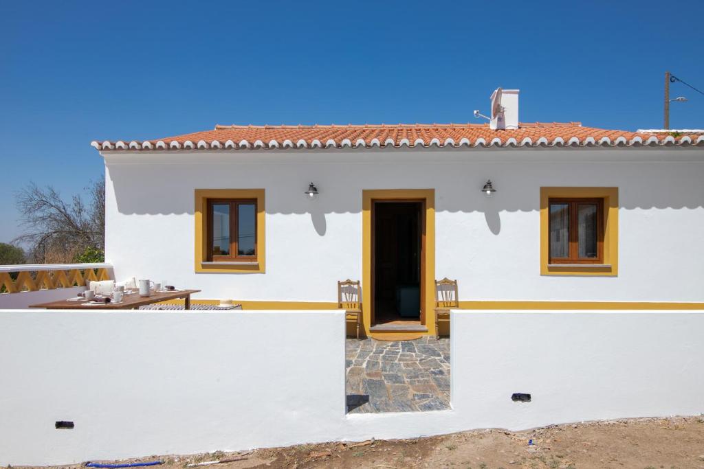 a white house with a door and a patio at Casas do Monte I in Giões