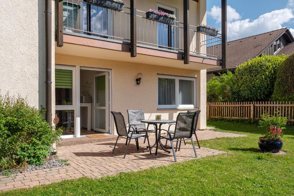 a patio with a table and chairs in front of a house at Haus Reiser in Alpirsbach