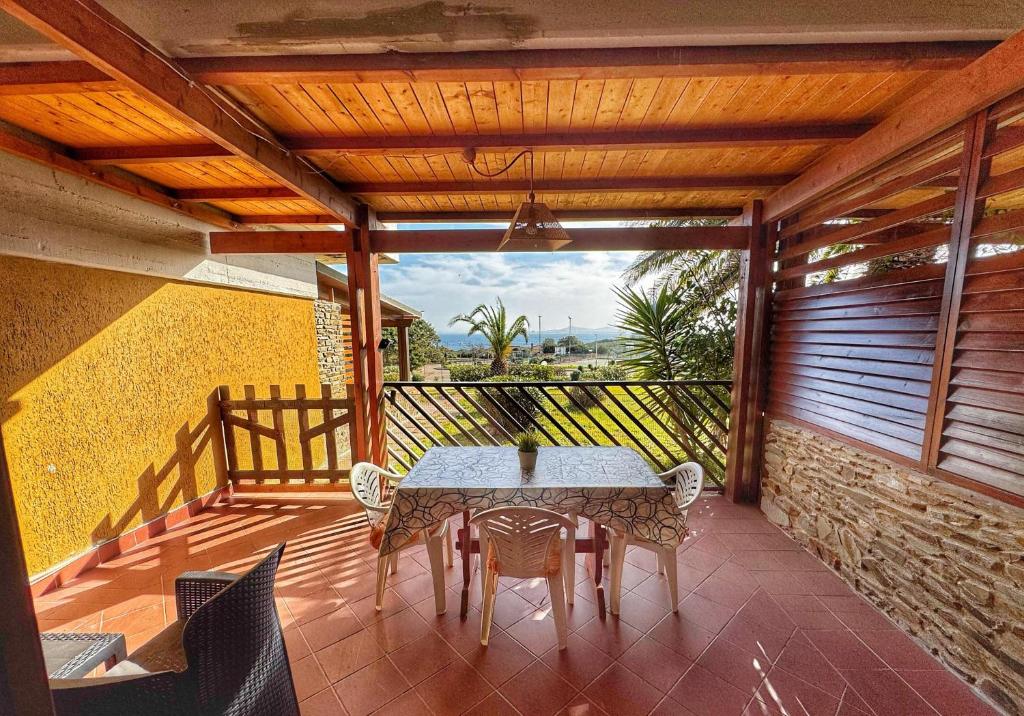 a patio with a table and chairs on a balcony at Casa 3 Punta Negra in Stintino