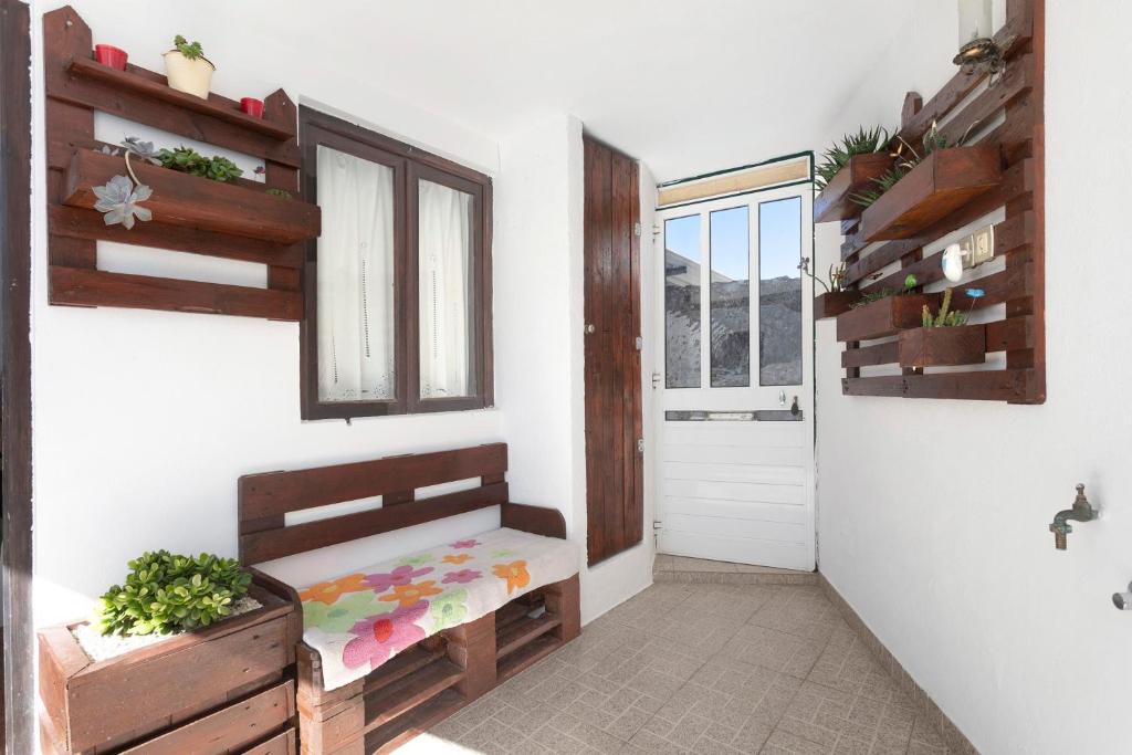 a hallway with a wooden bench and a window at Casinha Da Aldeia in Cela Velha