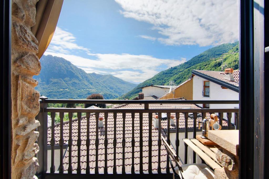 a woman standing on a balcony with a view of mountains at Casa Pollicina in Margno