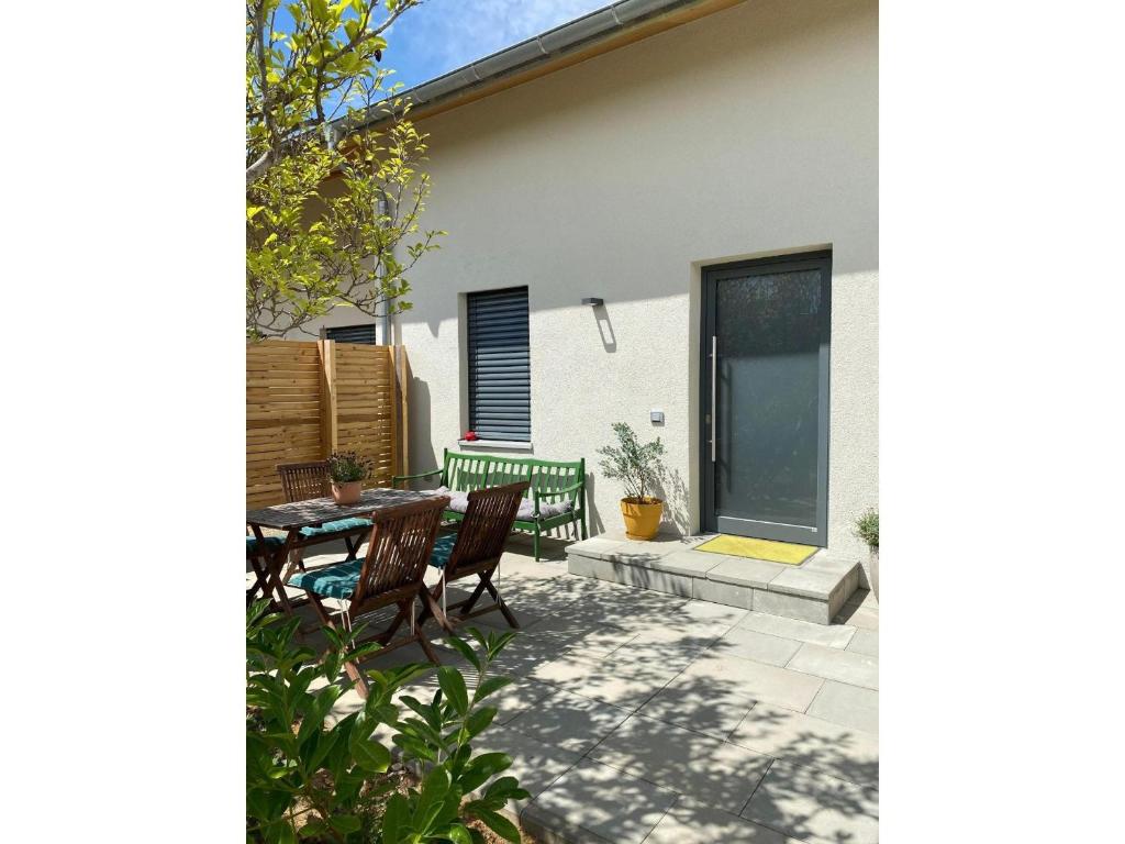 eine Terrasse mit zwei Stühlen, einem Tisch und einem Fenster in der Unterkunft Albnest in Mössingen