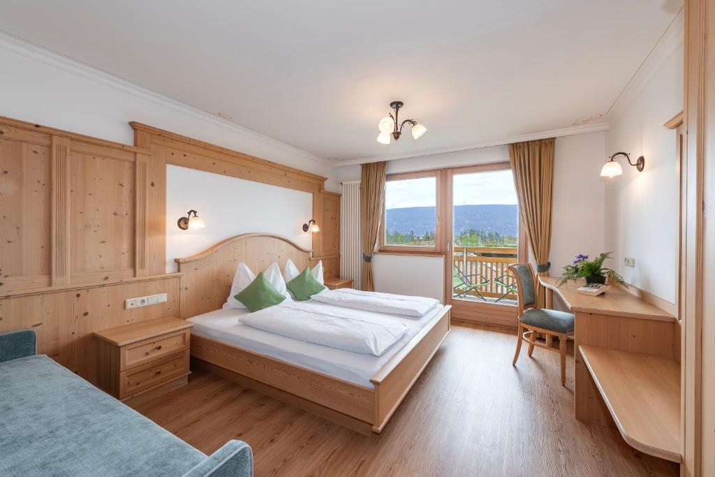 a hotel room with a bed and a desk and a window at Residence Diana Apartment 101 in Terento