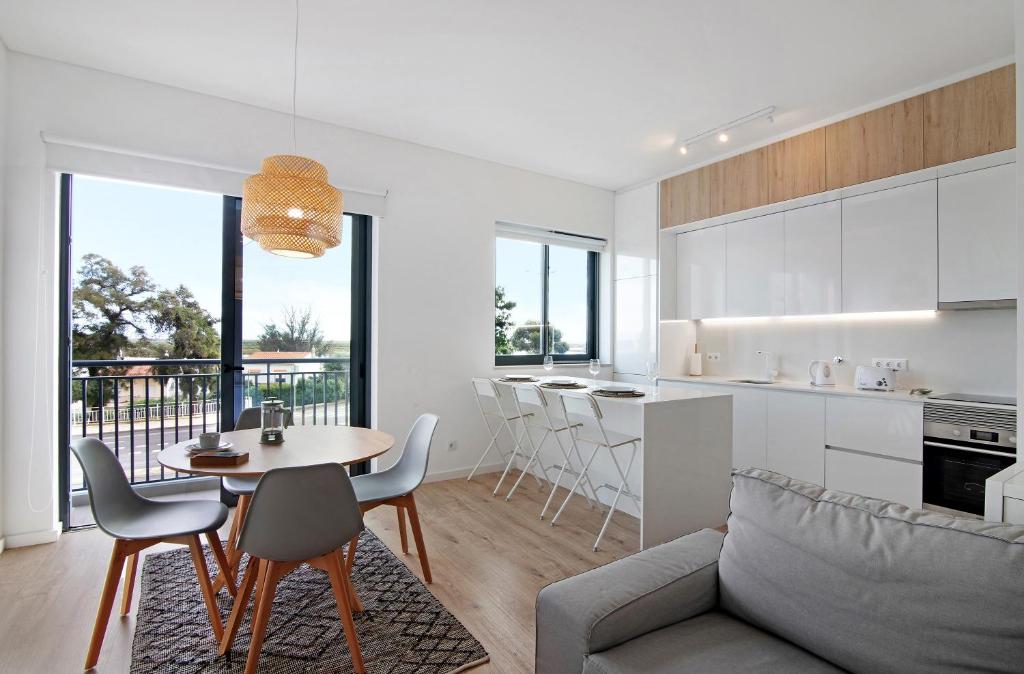 a kitchen and living room with a table and chairs at Formosa Home in Faro