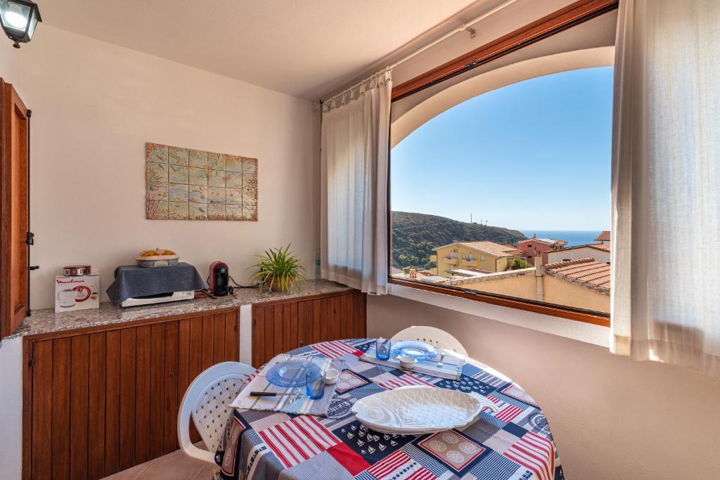 a bedroom with a table and a large window at Adriana's house in Buggerru