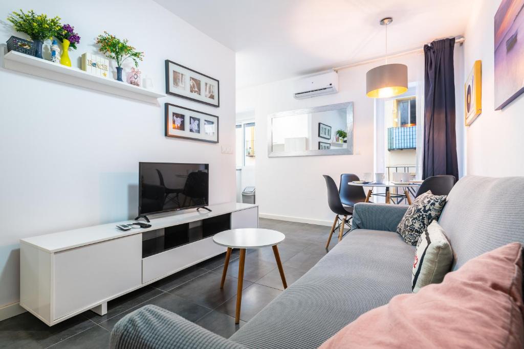 a living room with a couch and a tv at Apartamento Coral in Vinarós