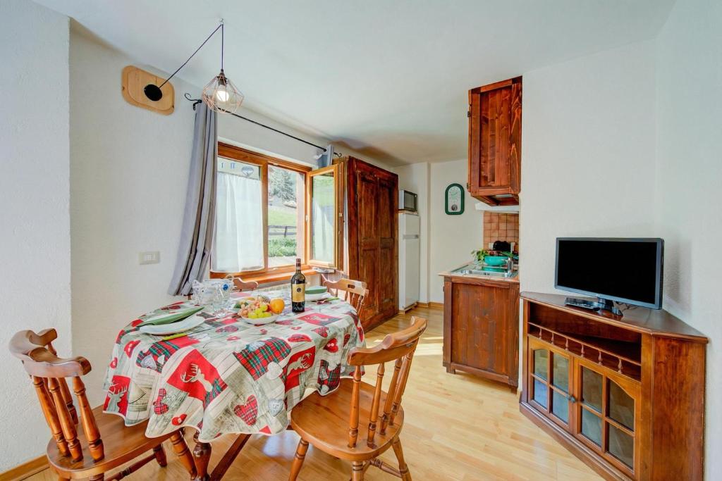 a dining room with a table and chairs and a television at Studio Clotes Ski In - Ski Out - Happy Rentals in Sauze dʼOulx