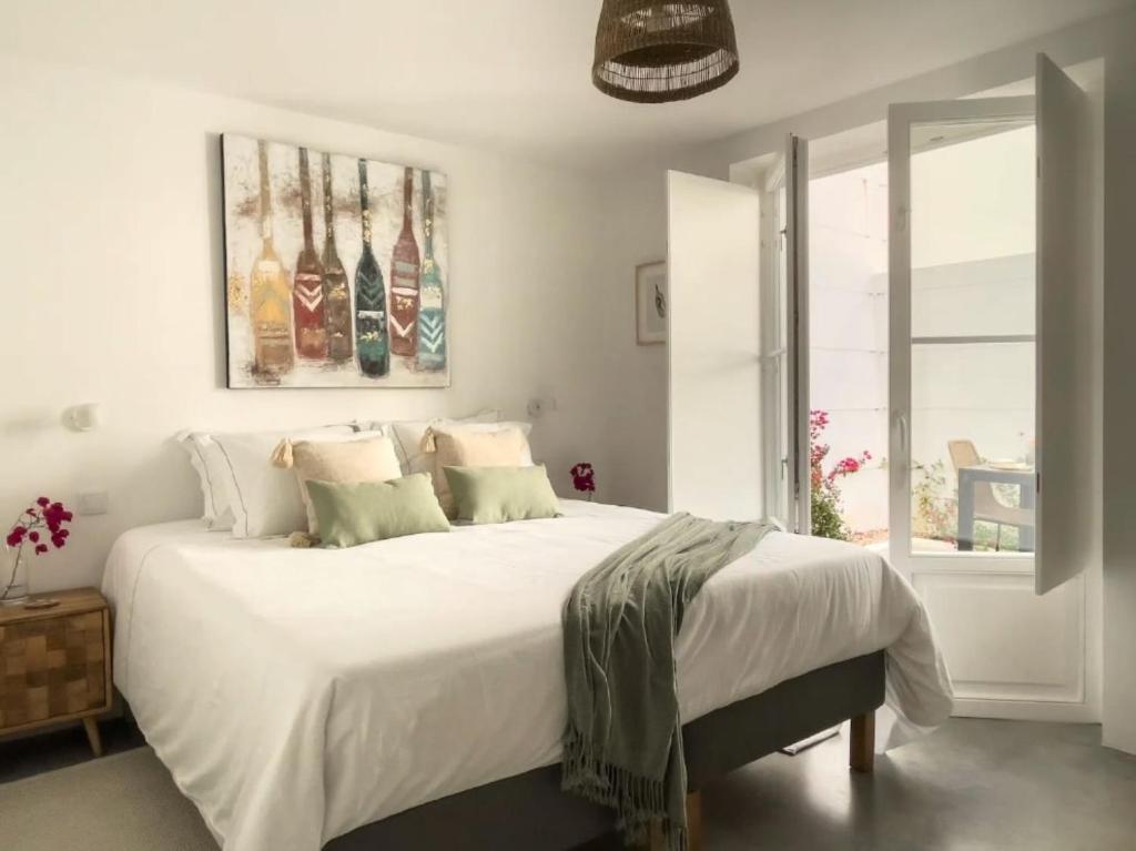a bedroom with a large bed with white sheets and pillows at Jasmine House in Tavira