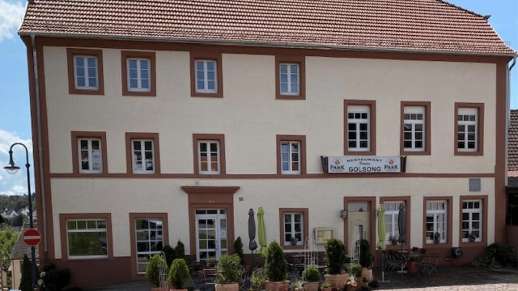 a large white building with a sign on it at Restaurant Fewo Golsong in Thaleischweiler-Fröschen