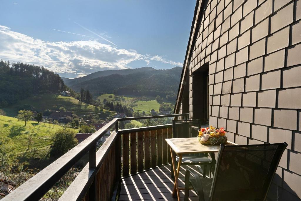 a balcony with a table and a view of mountains at Ferienhaus Schwarzwaldleben in Seebach
