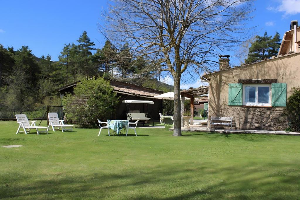 a yard with chairs and a table in front of a house at Villa la Myreclose in Saint-Auban