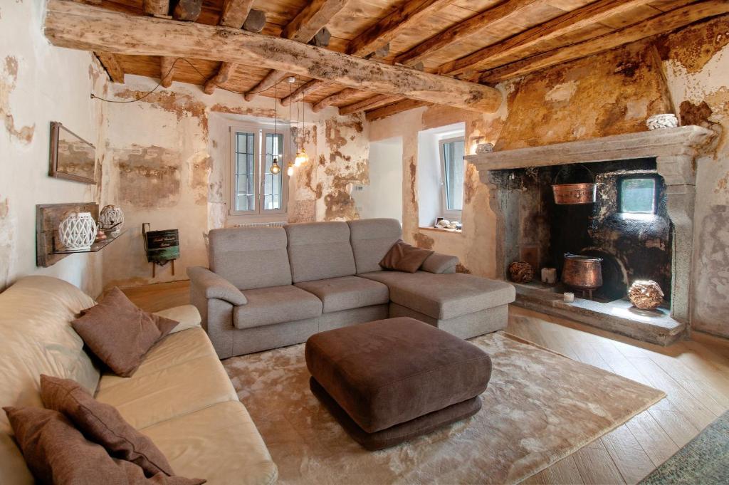a living room with a couch and a fireplace at Thari House Como Lake in Naggio