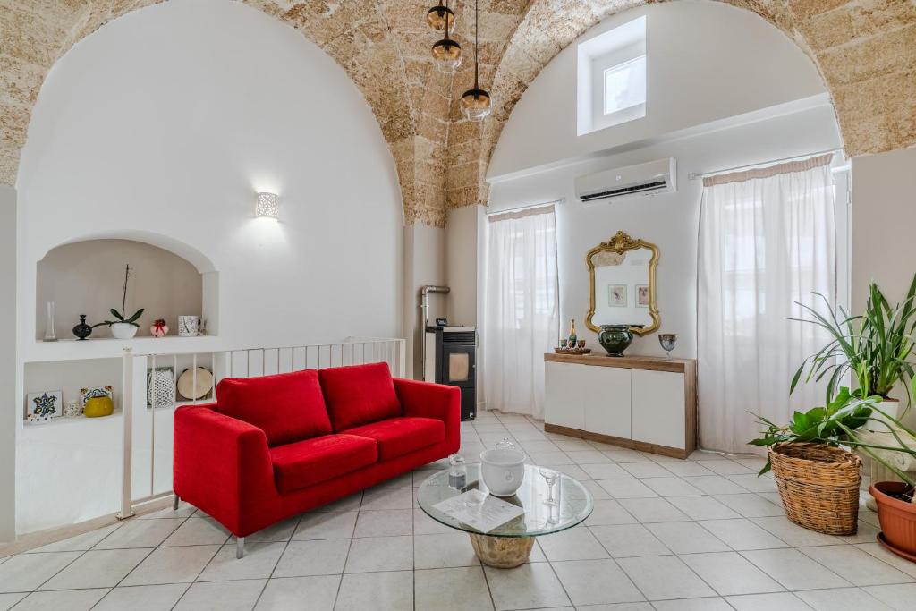 a living room with a red couch and a table at Civico4 luxuryholidays in Casarano