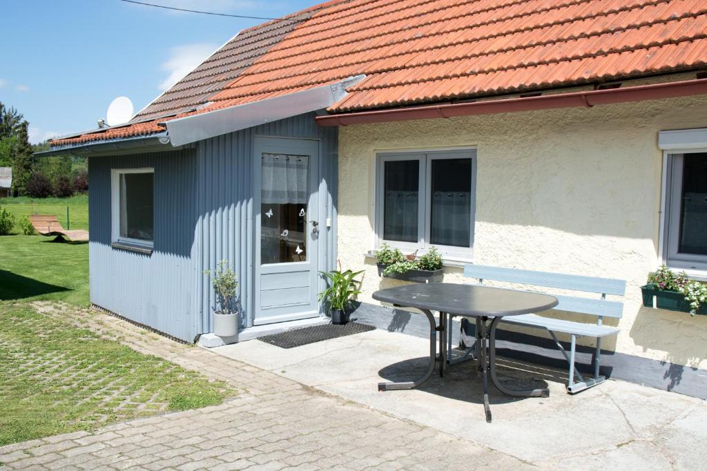 a small house with a table and a bench at Ferienwohnung Kleiner Spatz in Leutkirch im Allgäu