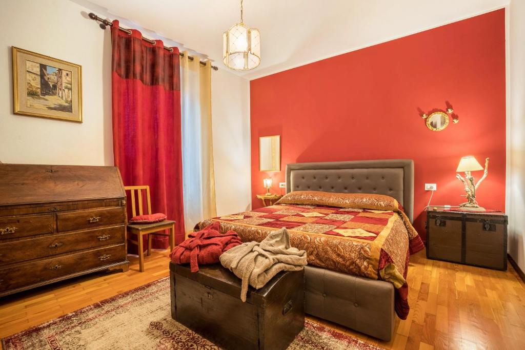 a bedroom with a bed and a red wall at Appartamento Collini in Spiazzo