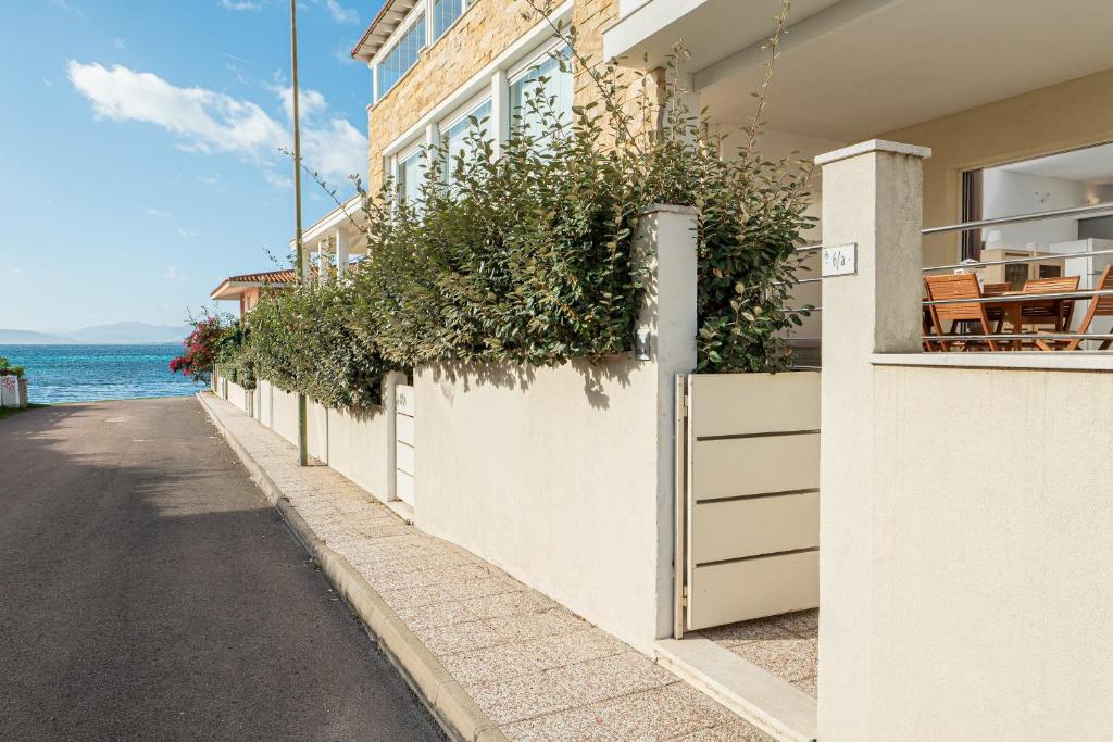 a white building with plants on the side of a street at Cormorani appartamento N 5 in Golfo Aranci