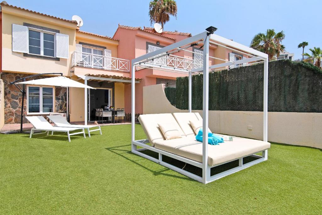 a yard with two white chairs and a house at Santa Ana 23 in Playa del Ingles