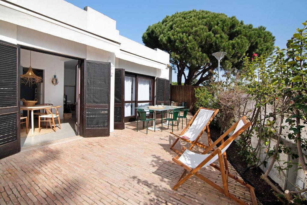 a patio with chairs and a table and a tree at Balaia 9 in Olhos de Água