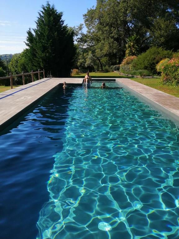 a woman and two children in a swimming pool at Casa de Andrães - Glicíneas in Marco de Canaveses