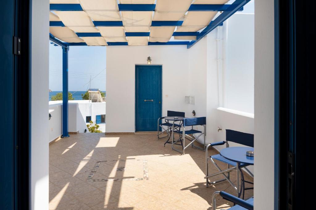 a room with a blue door and chairs and a table at Studios Ninemia Serifos 5 in Livadi