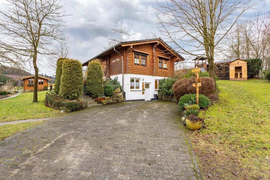 a wooden house with a driveway in front of it at Ferienhaus Hohlwegstübchen in Sundern