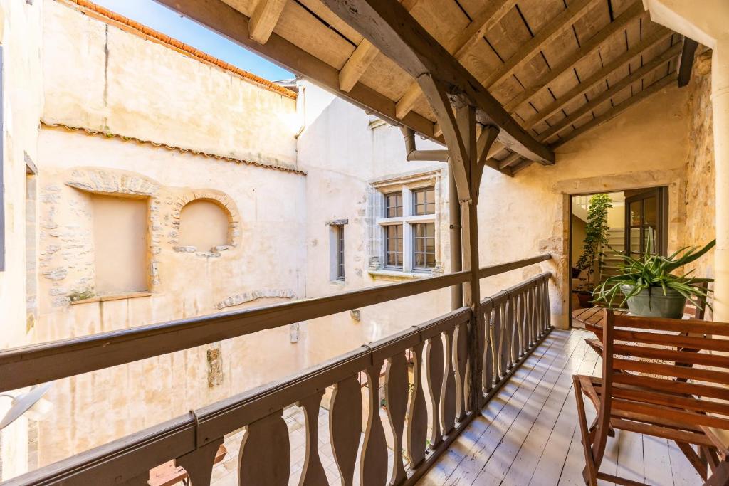 a balcony with a wooden bench and a building at Appartement Andraut - Bazas in Bazas