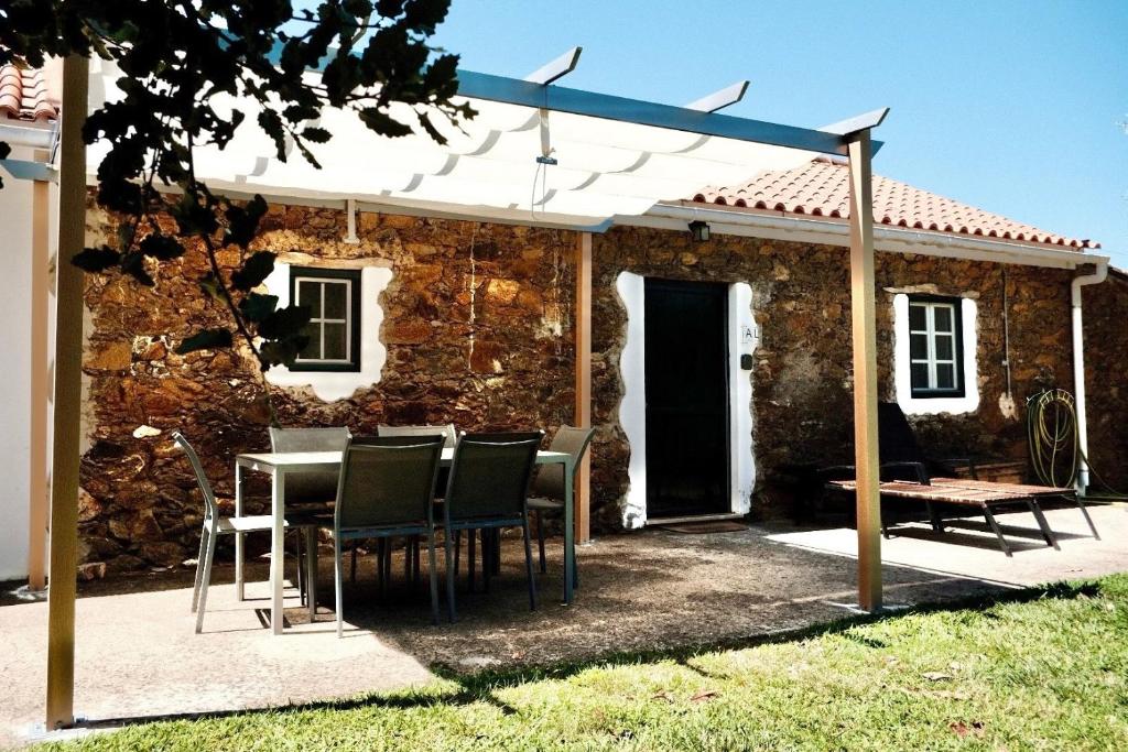a patio with a table and chairs in front of a building at Vale do Espinheiro in Espinheiro
