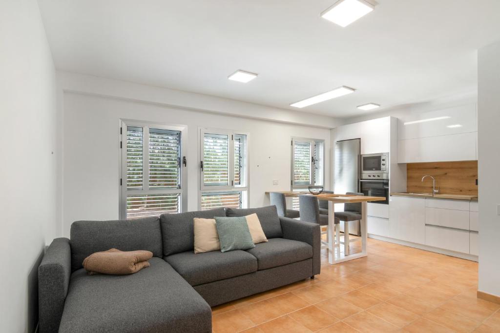 a living room with a couch and a kitchen at S Q Playa de Sardina in Gáldar