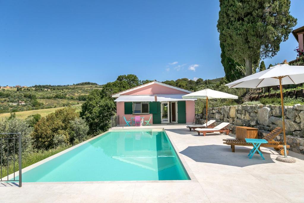 a swimming pool in front of a house at Casetta Maya in Riparbella