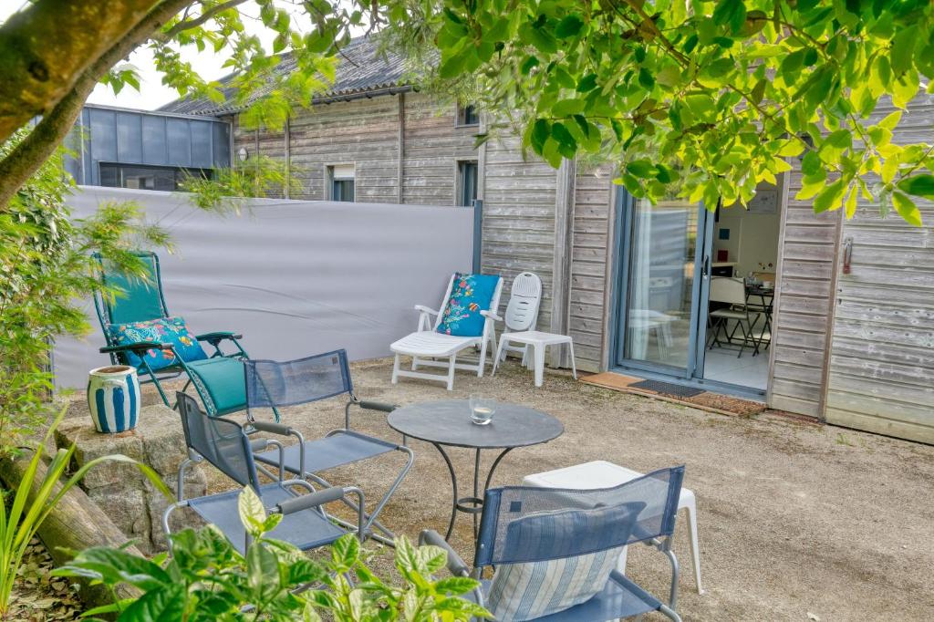 a group of chairs and a table in a yard at Le Refuge Salin in Batz-sur-Mer