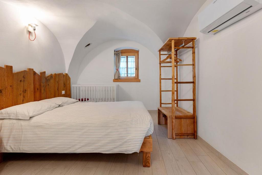 a bedroom with a bed and a wooden ladder at Logge dei Paroloti Agnese in San Lorenzo in Banale