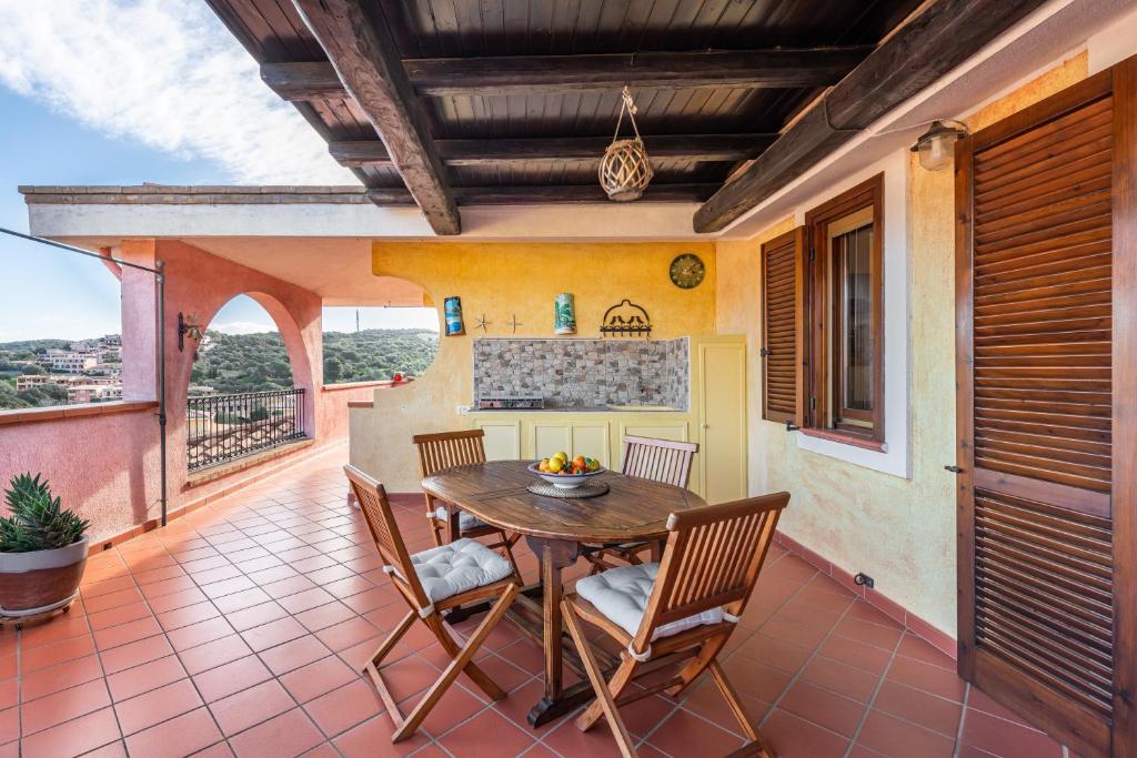 a patio with a table and chairs on a balcony at Attico il Mandorleto in Villasimius