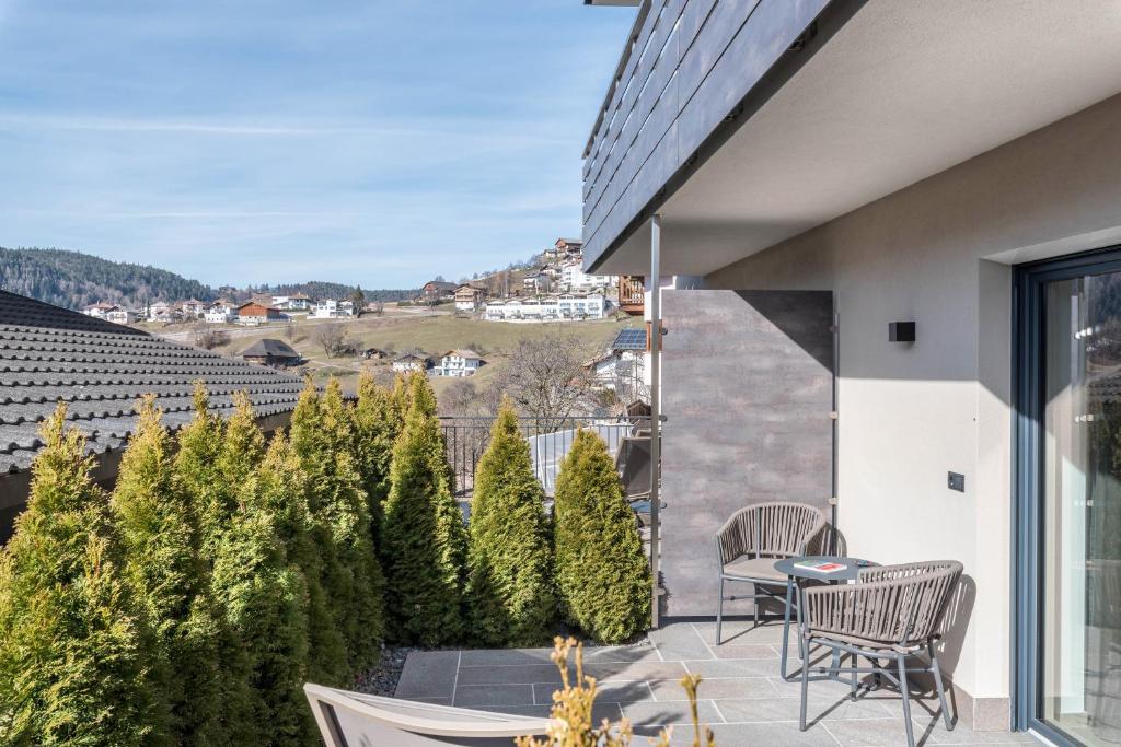 a balcony with chairs and a view of a city at Aster Moments Apt Max in San Genesio Atesino