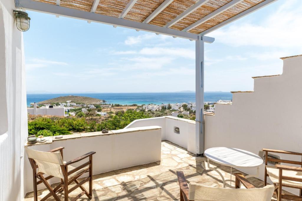 a balcony with chairs and a view of the ocean at Anemologio 304 Tinos in Agios Ioannis