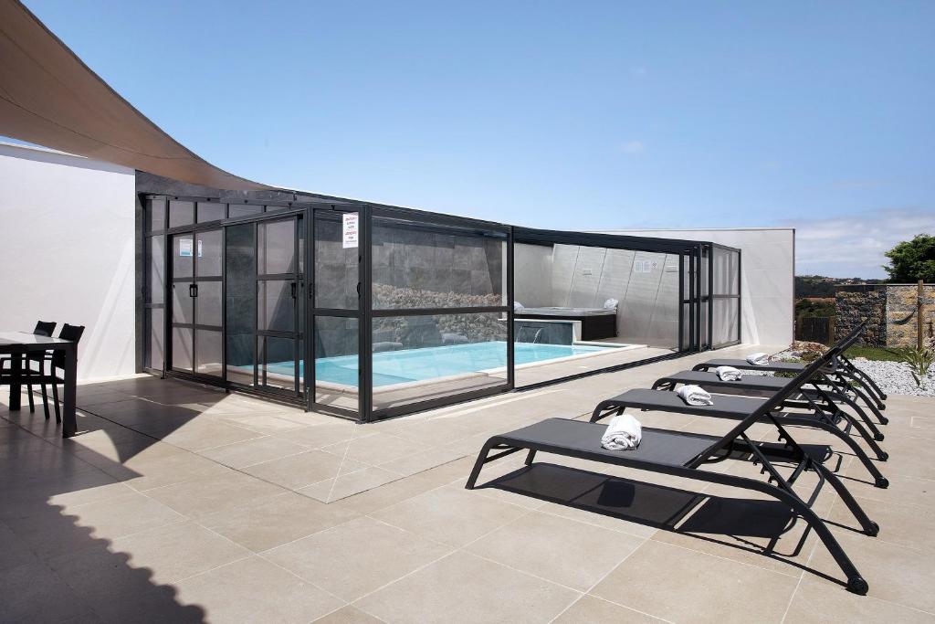 a patio with lounge chairs and a swimming pool at Villa Flor Rosa Piscina e Jacuzzi in Salir de Matos