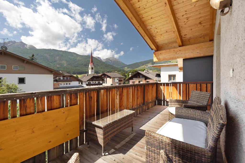 a balcony with chairs and a view of a town at Kriendl Nr 4 in Valdaora