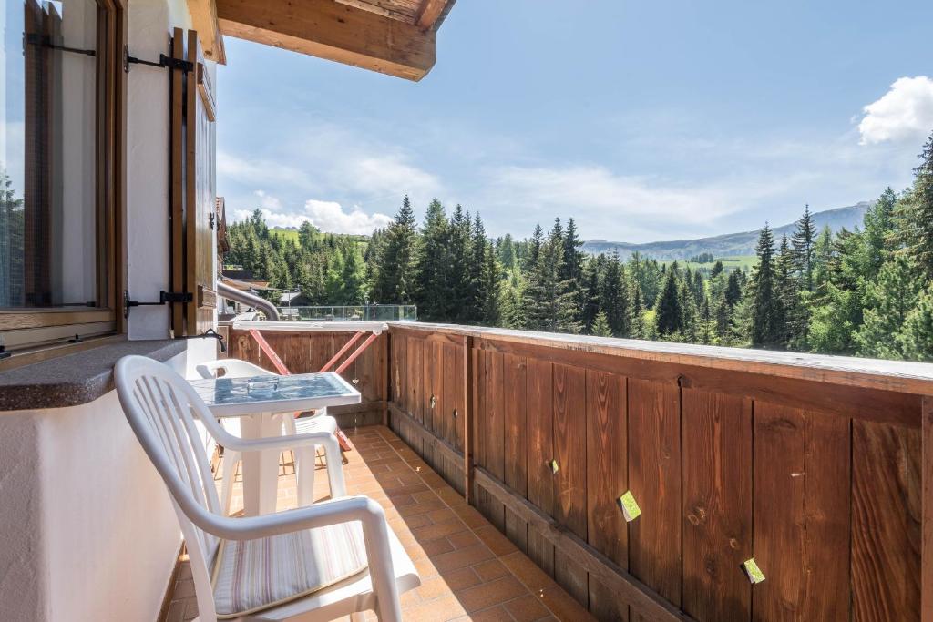a balcony with two chairs and a view of the mountains at Sabina Dolomites Puflatsch in Alpe di Siusi