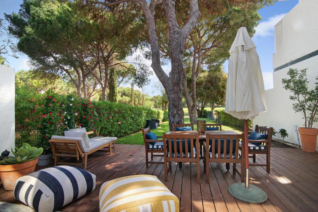 a patio with a table and chairs and an umbrella at Vilamoura com Piscina e Wifi in Vilamoura