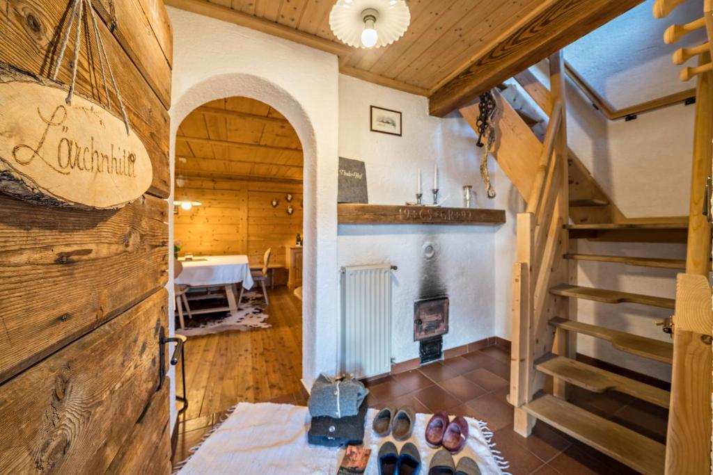a large room with a staircase and a table at Thaler-hof Ferienhaus Lärchnhittl in Lagundo
