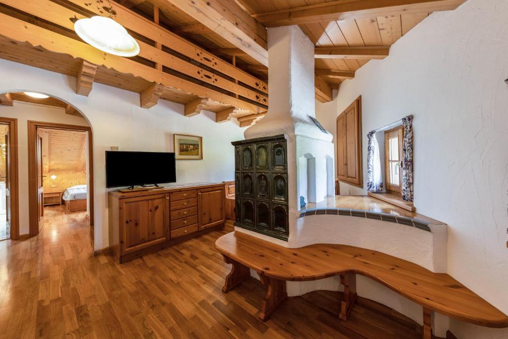 a living room with a fireplace and a tv at Ciasa Sommavilla Mansarda in Vigo di Fassa