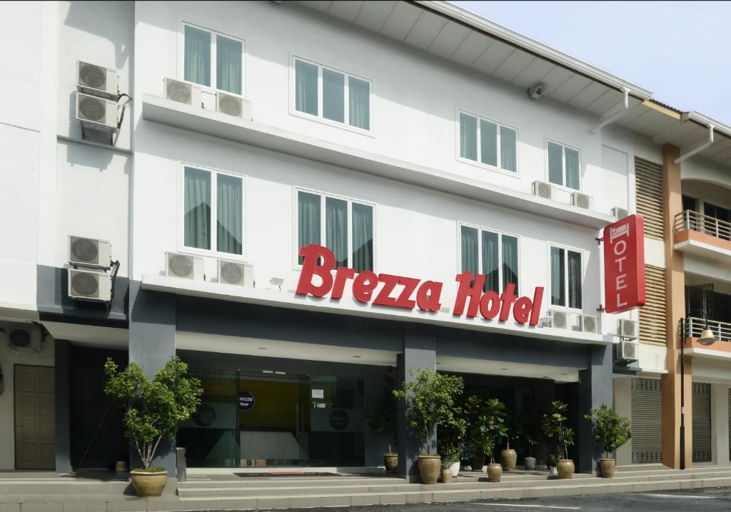 a hotel with a red sign on the front of it at Brezza Hotel Lumut in Lumut