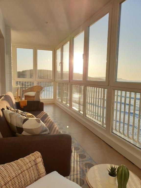 a living room with large windows and a couch at Piso en el Mar in Salinas