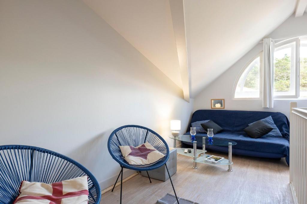 a living room with two chairs and a blue couch at Appartement Le Moulleau in Arcachon