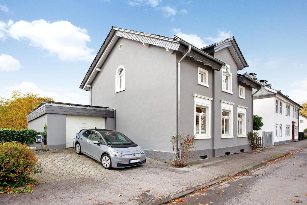 a car parked in front of a white house at Ferienwohnung im Eichholz in Arnsberg