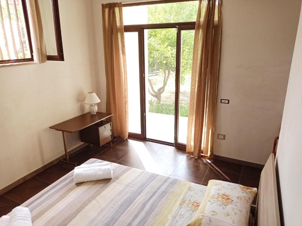 a bedroom with a bed and a desk and a window at Germogli di Prumo in Castelnuovo Cilento