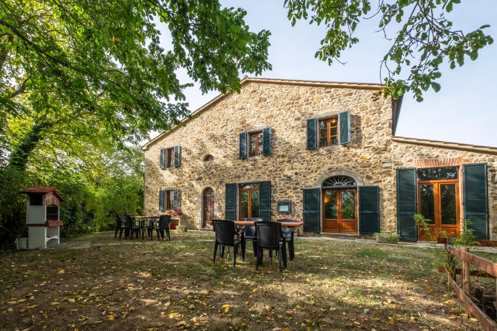 an exterior view of a stone house with a table and chairs at Girasole in Arcidosso