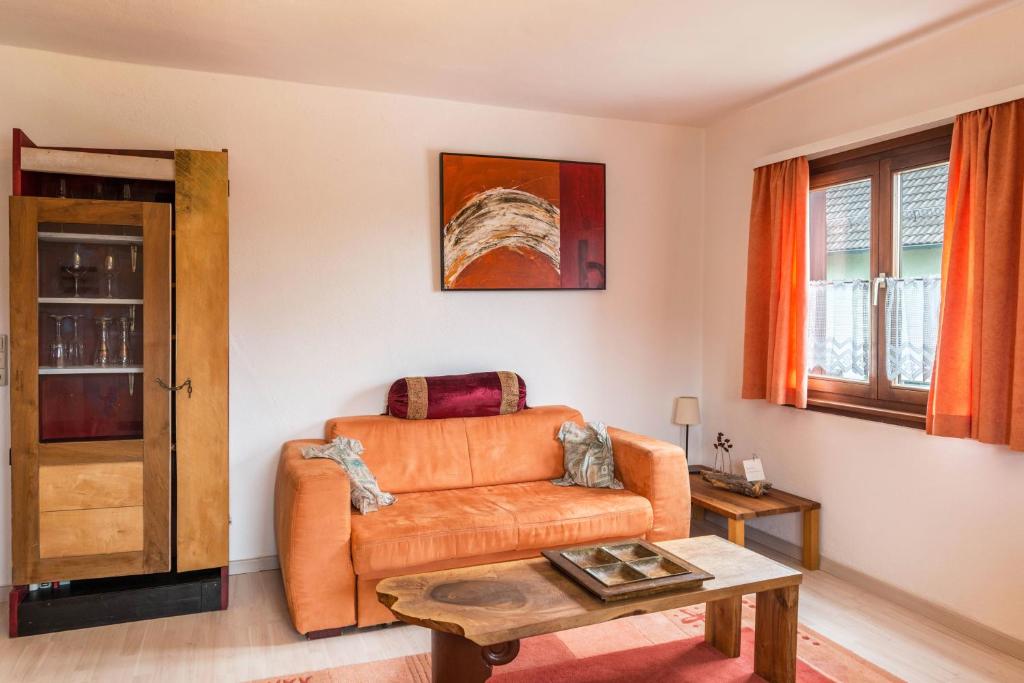 a living room with an orange couch and a table at Familienwohnung Haus 18 in Überlingen